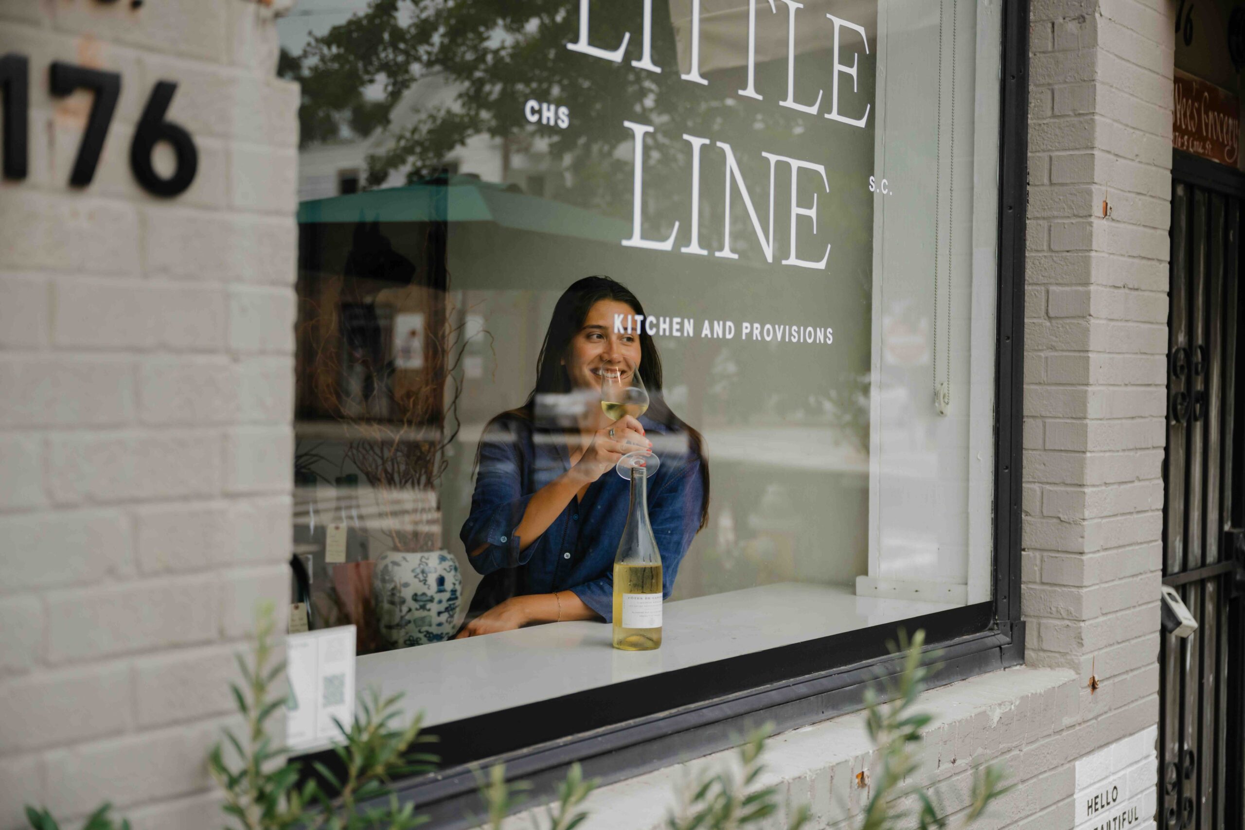 A candid, warm lifestyle photograph taken through the window of a modern cafe named 
